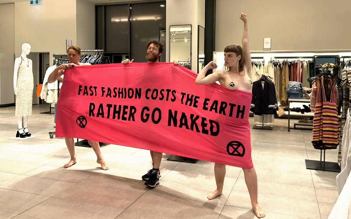 Inside a clothing store: three nearly naked rebels stand in a banner