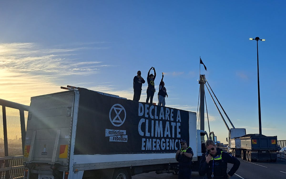 Rebels on truck on Westgate Bridge with giant XR banner 'Declare a climate emergency'.