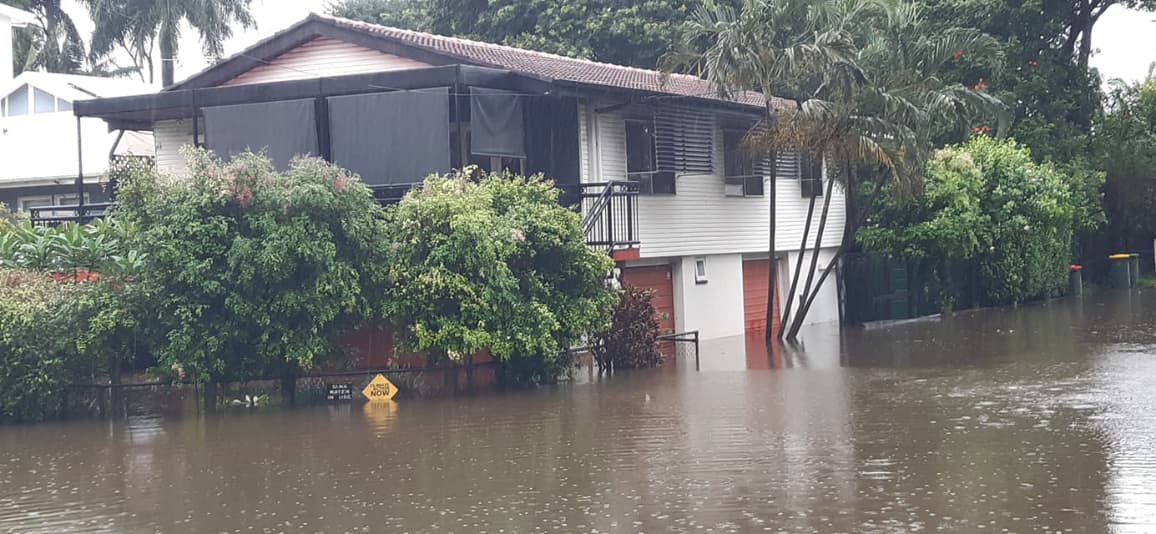 Flooded Brisbane house, with Climate Action sign