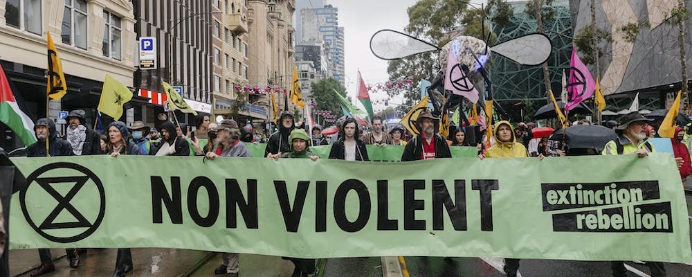 Mass slow march with banner non violent Extinction Rebellion