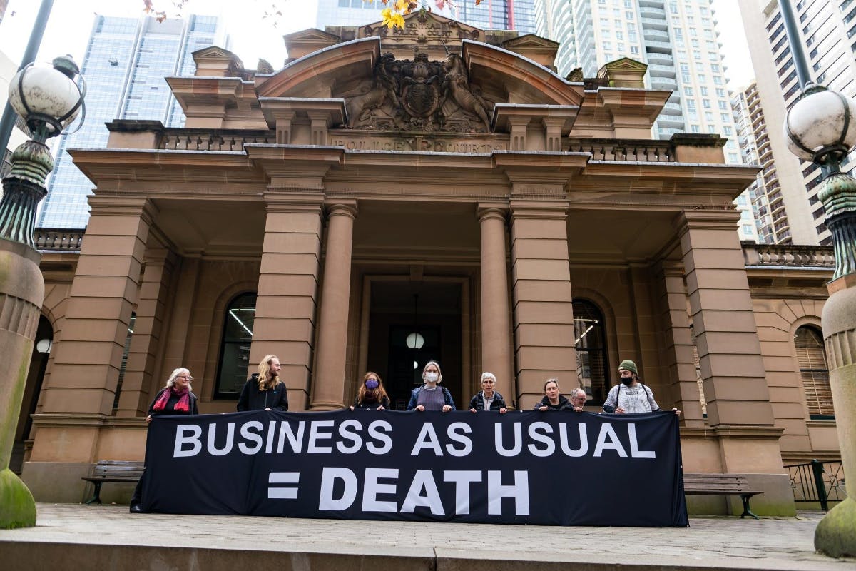 Activists with 'Business as Usual = Death' banner
