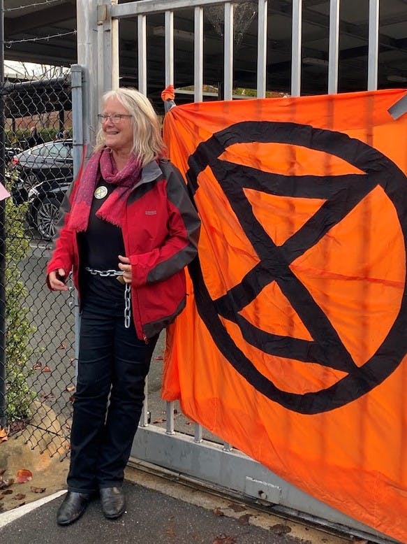 Jane Morton chained to a fence with the XR banner