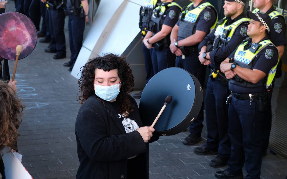 Protester banging drum outside the conference