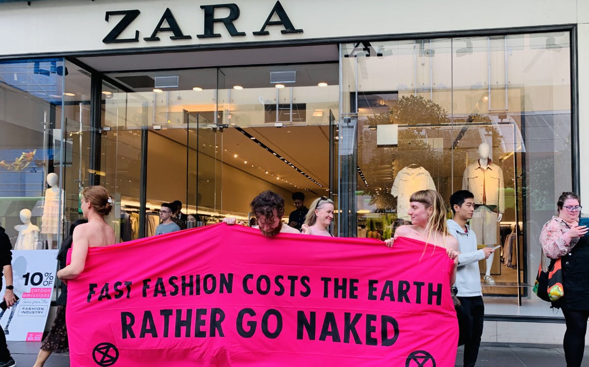 Outside the Zara clothing store: three nearly naked rebels stand in a banner