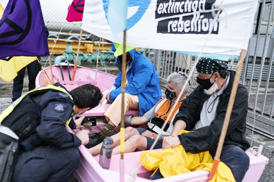 XR protesters blocking the Exxon gate in a pink boat