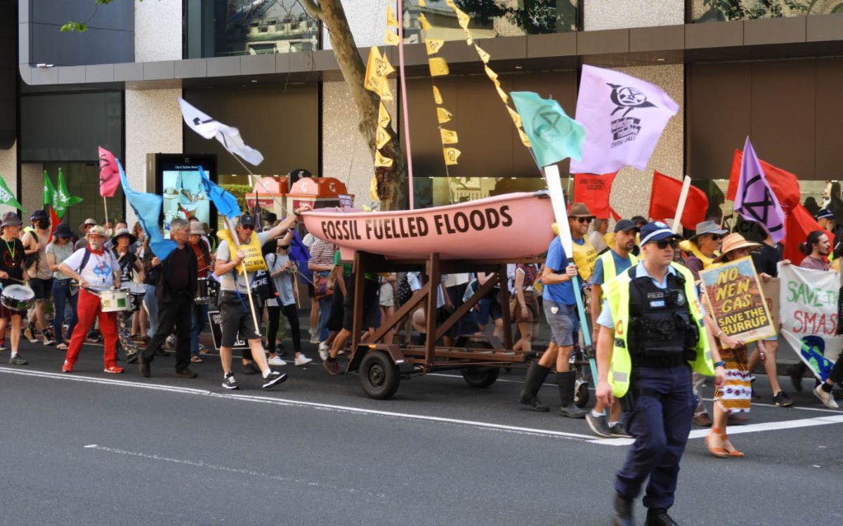 XR rebels with a pink boat labelled 'fossil fuelled floods'