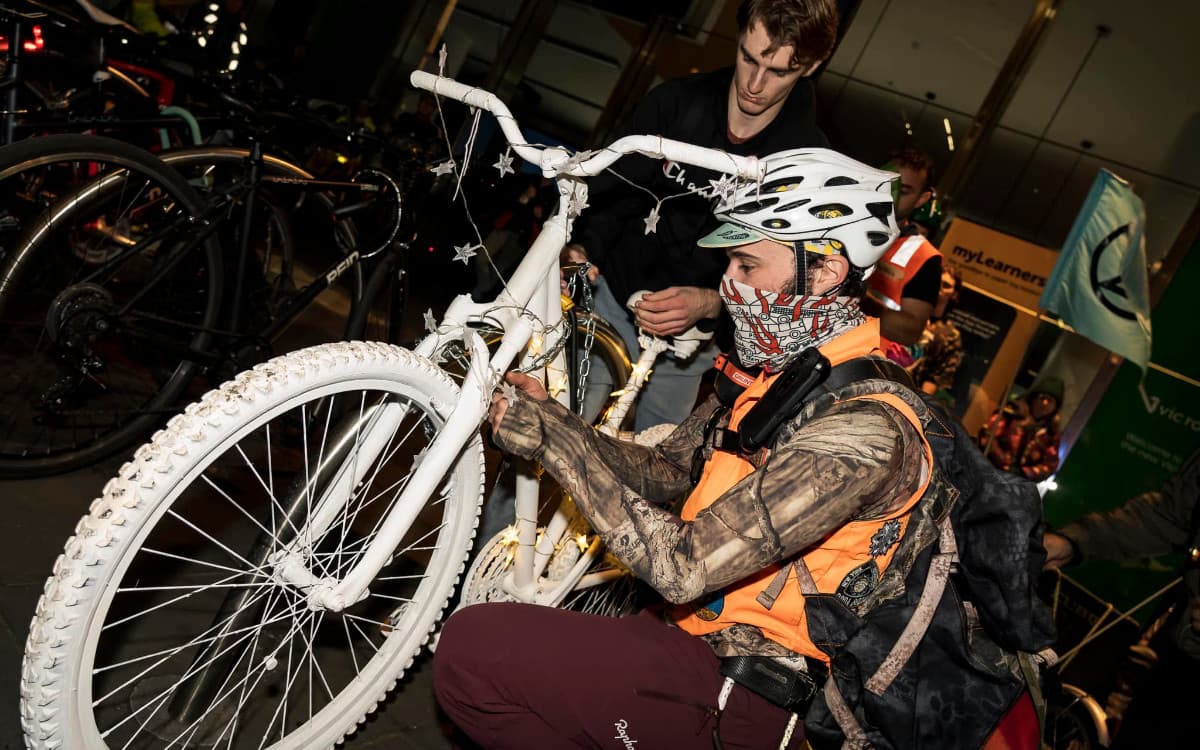 Installing a white-painted 'ghost bike' in front of VicRoads