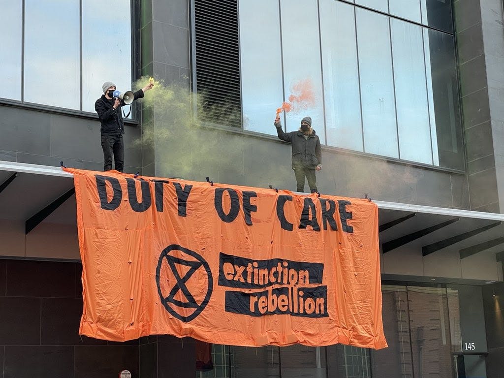 XR rebels in Melbourne above the entrance to the office of Federal Treasurer Josh Frydenberg.