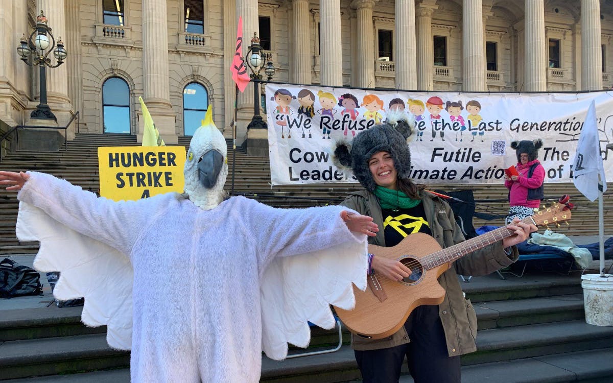 Supporter in a white cockatoo costume with others at the hunger strike