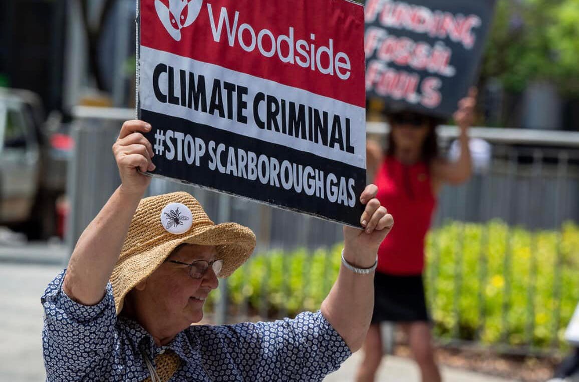 XRWA Grandparent holds sign reading 'Woodside Climate Criminal #stopScarboroughGas