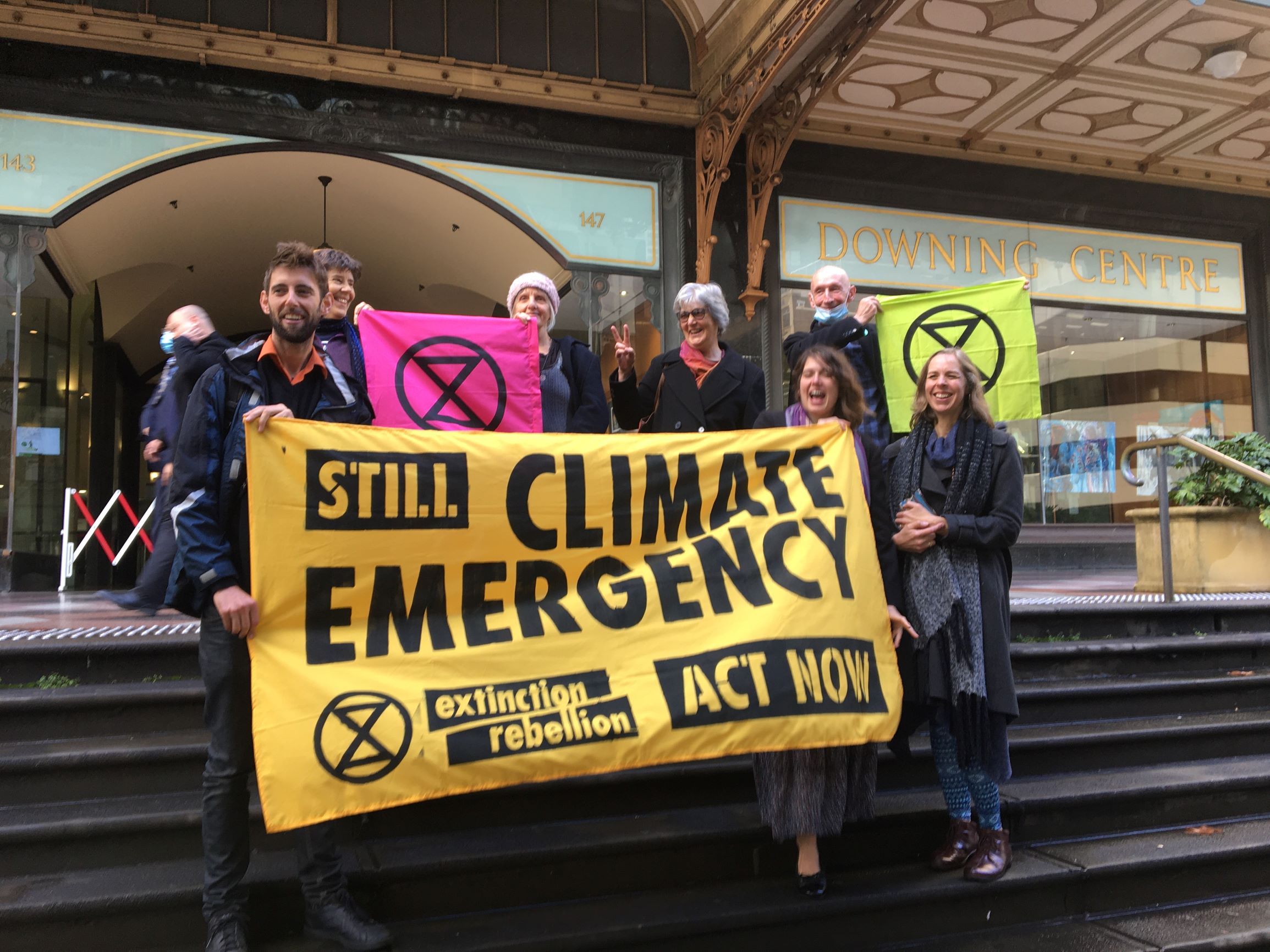 XR Rebels holding a banner celebrate outside Downing Court