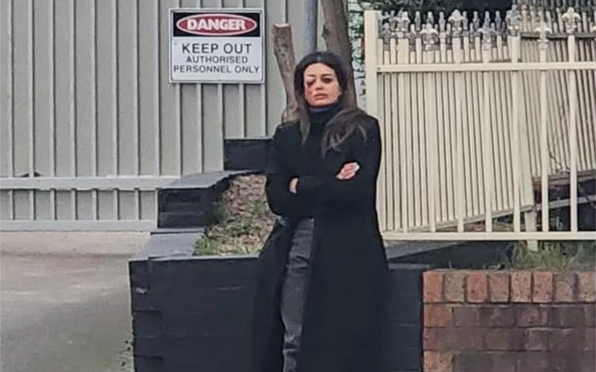 An injured Hannah Thomson waiting near police after her arrest