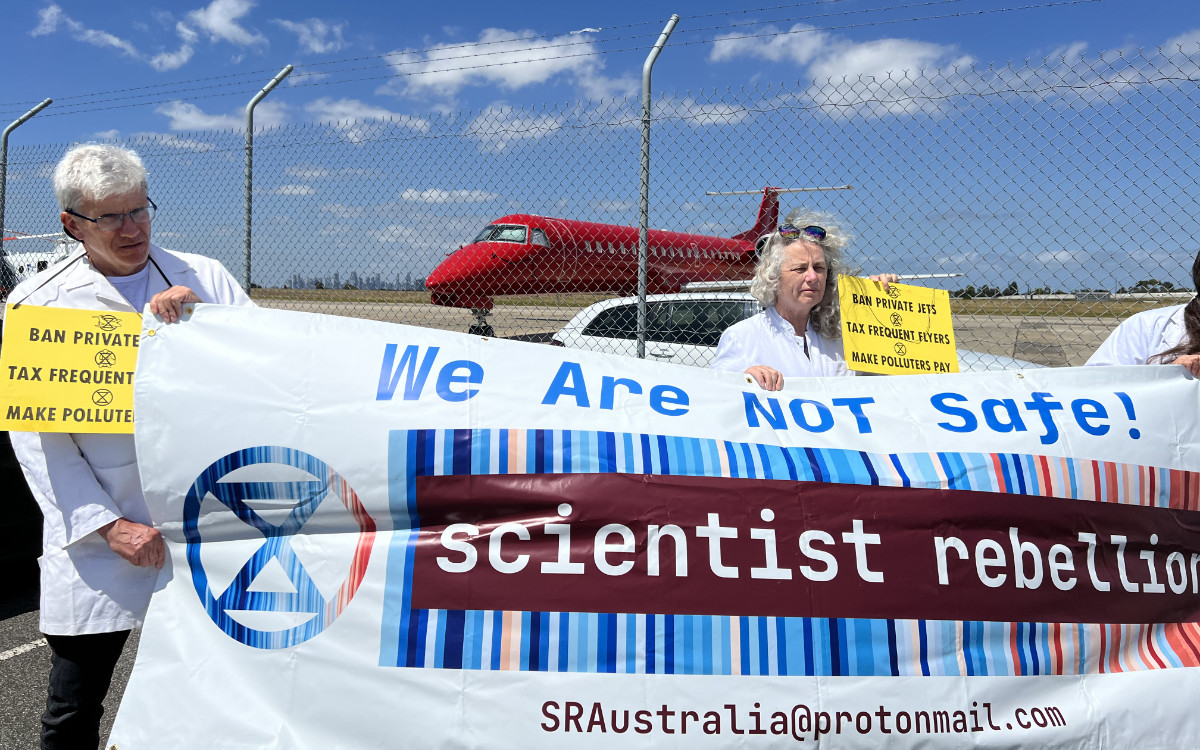 Scientist Rebellion rebels holding a banner at Essenden Airport