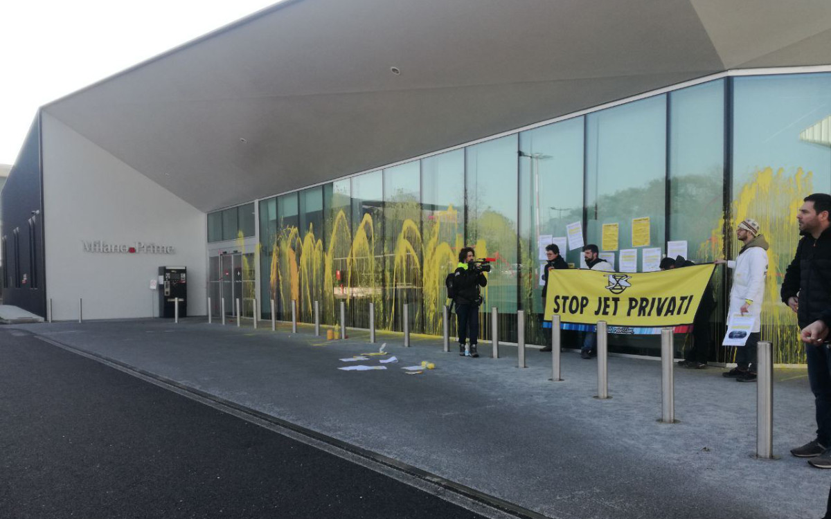 Activists spray yellow paint on the window of Milan Airport