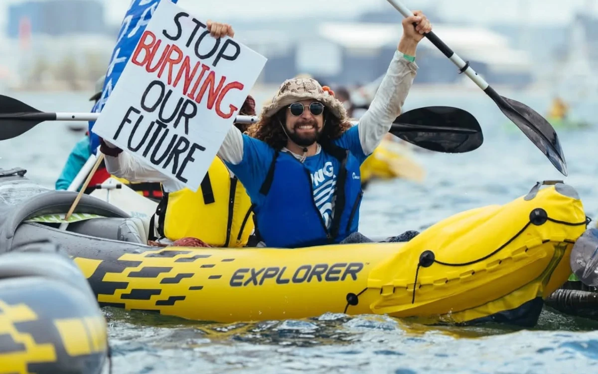 Kayaker with a sign 'Stop burning our future'