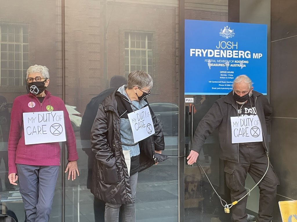 XR Rebels with hands glued to Josh Frydenberg's office windows