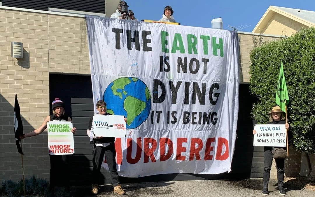 Environmental protesters hang a banner from Viva Scott Wyatt's roof