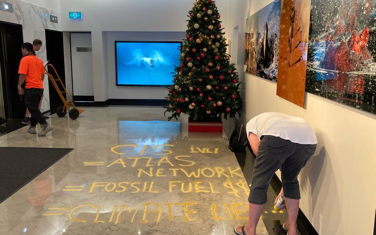 protester spraying slogans on the floor inside the CIS office building