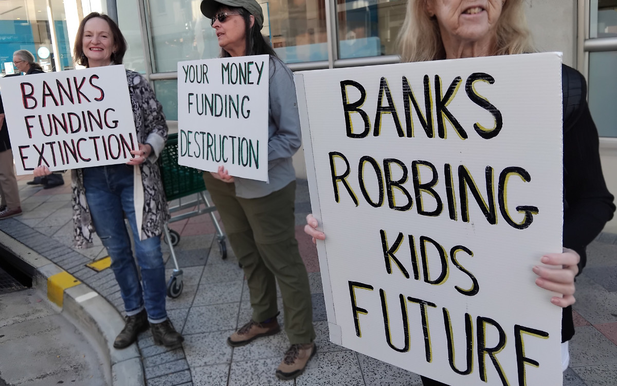 protesters with placards outside the ANZ bank