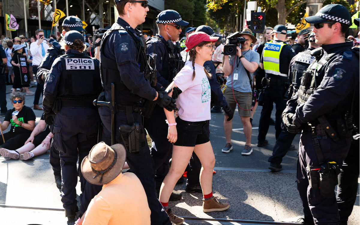 Protester being escorted away by several police